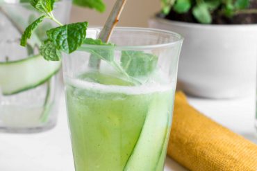 aloe vere cucumber cooler in glass with mint sprig and aloe vera leaf
