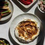 Labneh with dukkah and side dishes including kohlrabi salad, roasted paprika and zucchini, and a middle eastern salad