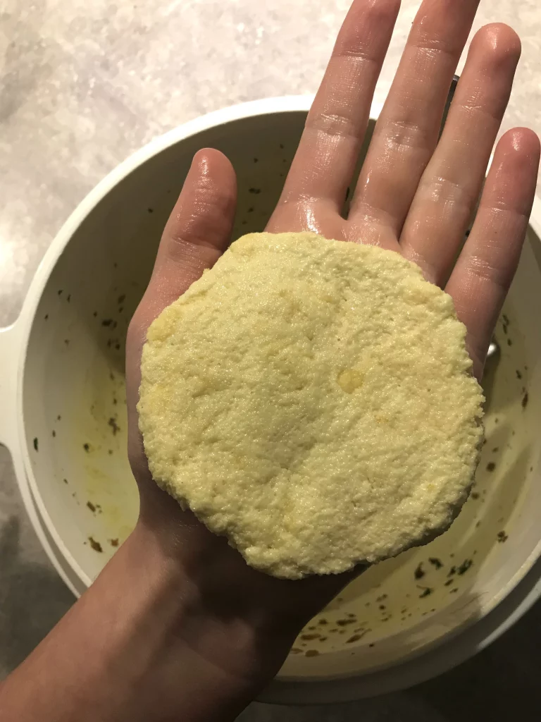 Semolina dough flattened in the palm of a hand