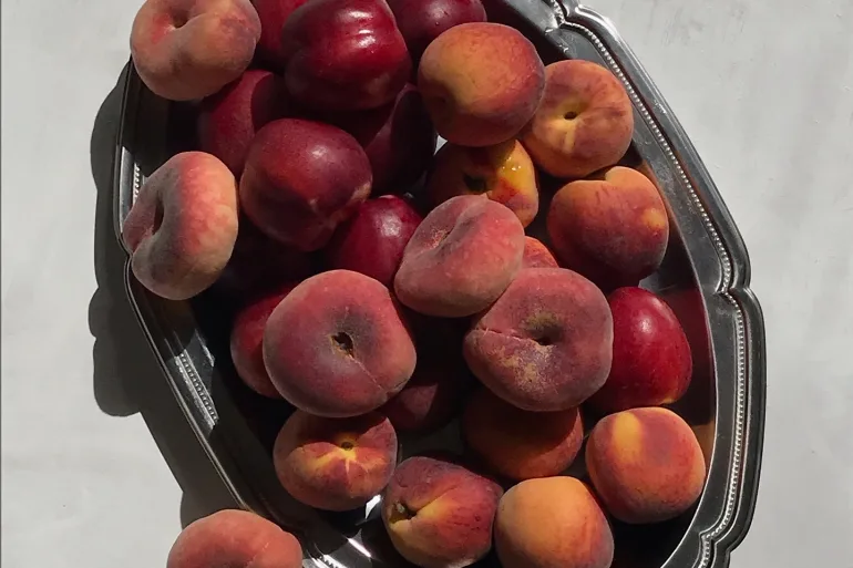 silver tray with different types of peaches