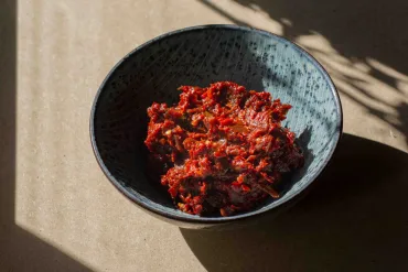 Sambal Badjak in a blue bowl among shadows
